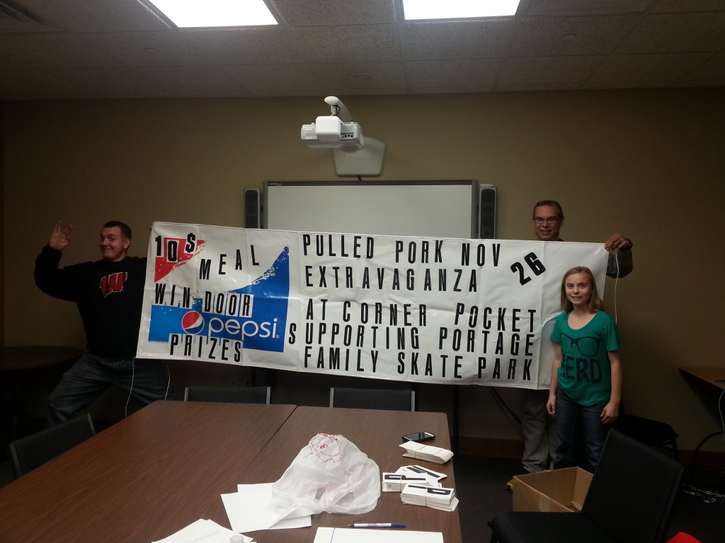 Sterling, Todd, Mariya putting the finishing touches on one of the event banners.