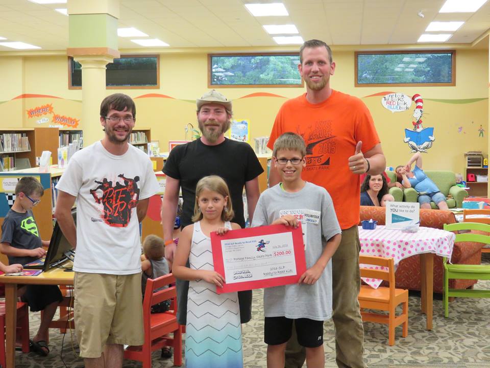 The winning charity, The Portage Family Skate Park, is represented by Kyle Little, Andrew Tamminga, and Jared Pierson. Reader, Ally Saloun and her brother (and teen volunteer) Jeremy Saloun, present a check for $200.00.